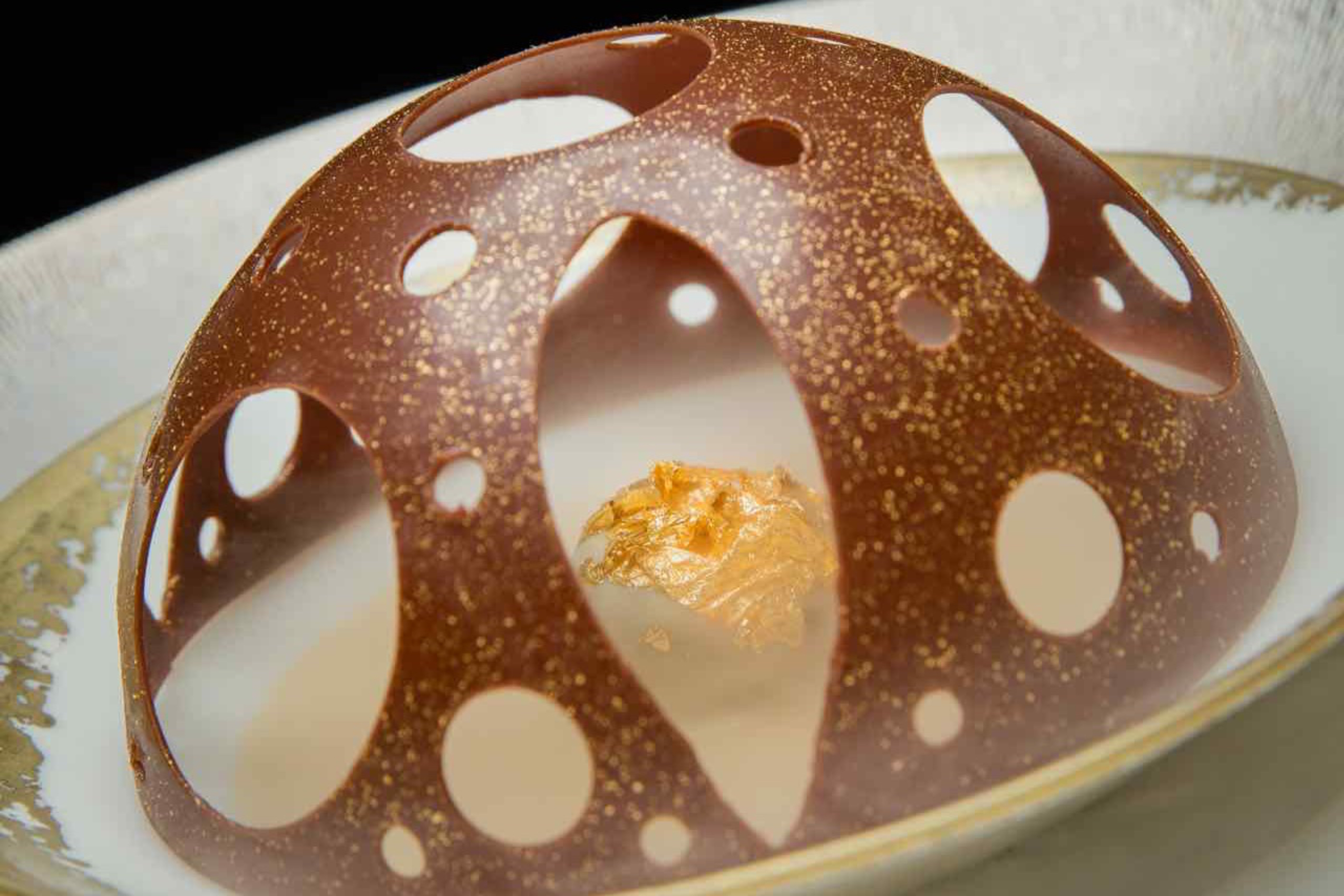 造型如同天巢圓頂的「經典朱古力慕斯圓頂伴特色啫喱」，大片金箔與乾冰效果將這款甜點營造得很有氣勢。