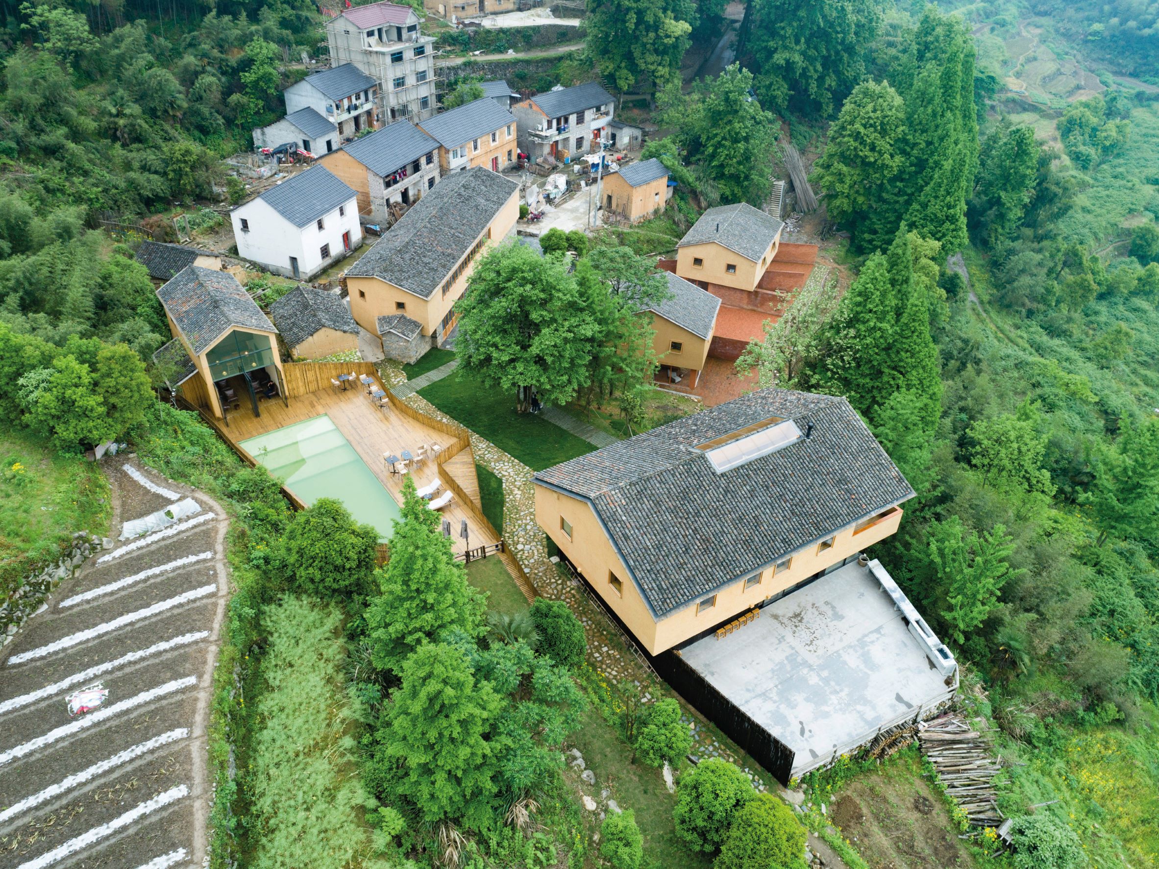 保留土牆與灰瓦屋頂的「大山初里」，讓民宿自然融入山村景色中。