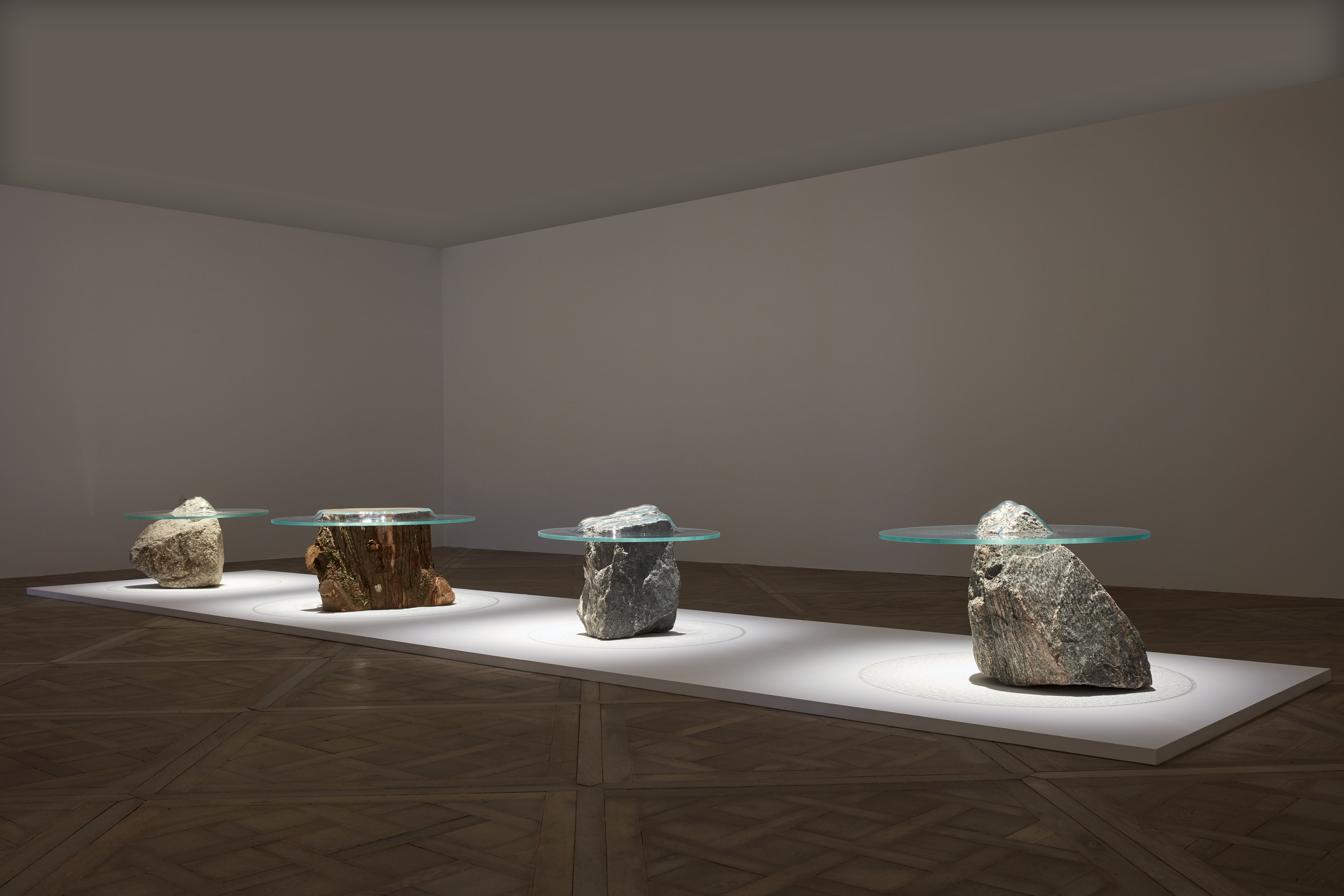 玻璃猶如「陷入」石頭中的 SLUMP 桌子系列，Paul Cocksedg 以精密 的計算讓玻璃完美嵌入，彷彿靜置的水面，賦予了石頭桌另一種生命力。