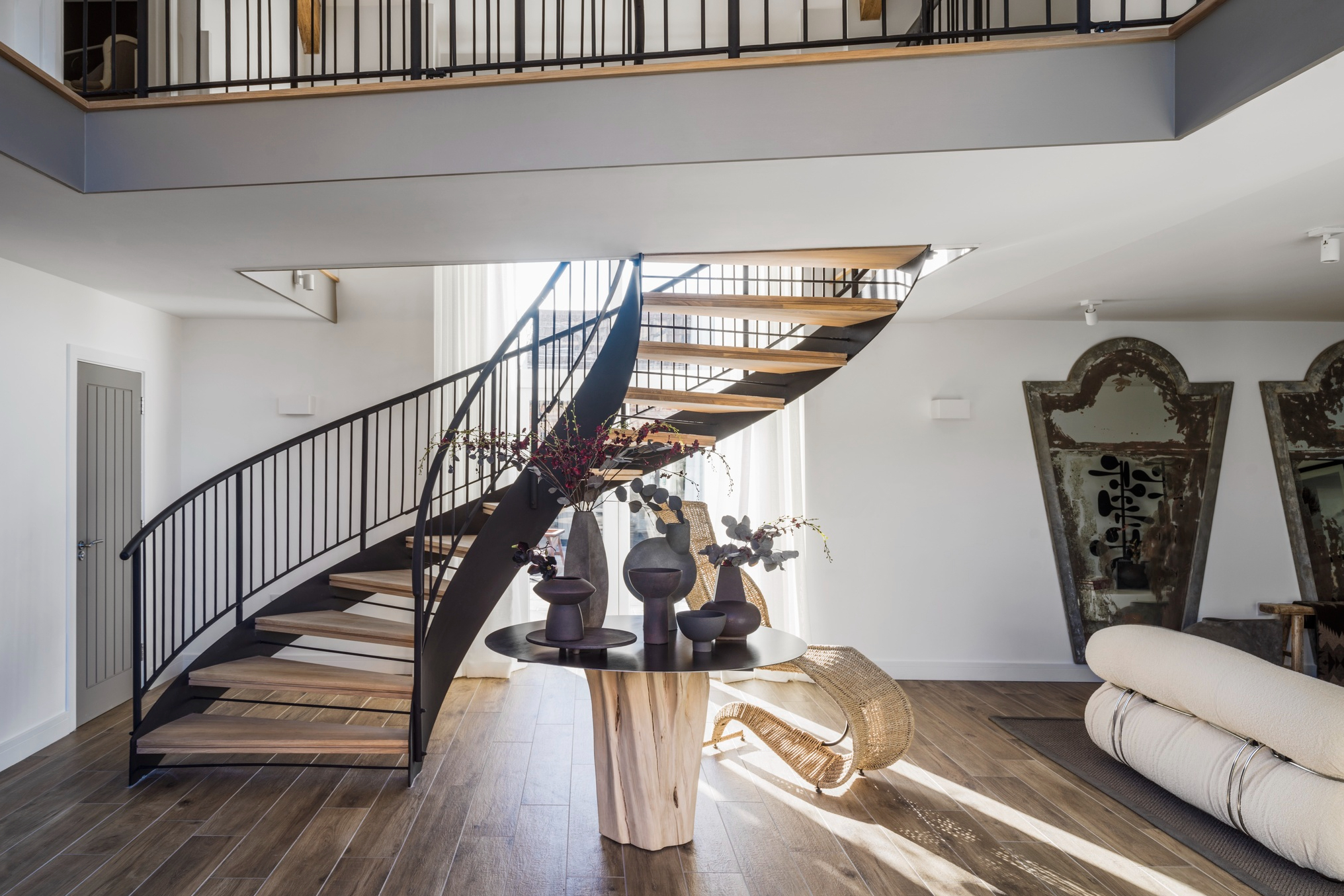 現代感的白色巨型迴旋吊燈和優雅鏤空的黑色螺旋樓梯、欄杆，形成鮮明對比，既現代又復古。