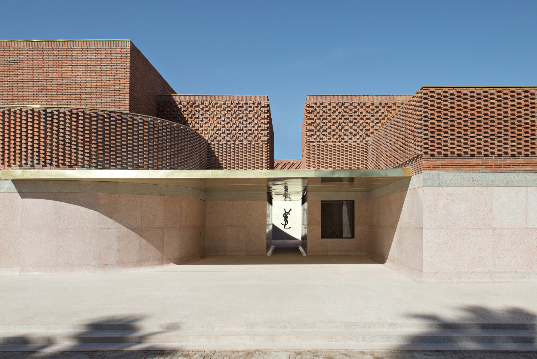 以赤土、混凝土、水磨石為主建材的 Musée Yves Saint Laurent Marrakech， 在建築上半部以紅磚組合出如同織品車線的牆面紋理。（ © Fondation Jardin Majorelle / Photo by Nicolas Mathéus）